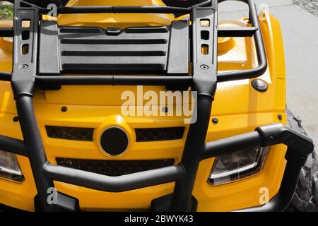 Photo of a yellow offroad touring atv vehicle standing on a road close-up upper hood with headlights view. Stock Photo
