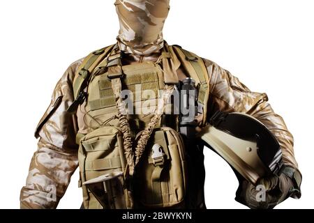 Isolated photo of a fully equipped soldier in uniform, armor standing and holding helmet with glasses. Stock Photo
