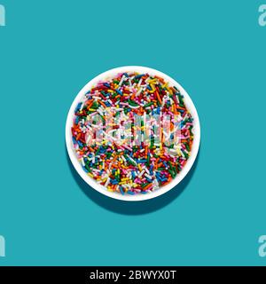 Bowl of rainbow sprinkles with blue background Stock Photo