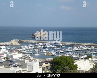 Muscat, Oman’s port capital, sits on the Gulf of Oman surrounded by mountains and desert. Oman, officially the Sultanate of Oman, is a country on the southeastern coast of the Arabian Peninsula in Western Asia. With history dating back to antiquity, it mixes high-rises and upscale shopping malls with cliff top landmarks such as the 16th-century Portuguese forts, Al Jalali and Mirani, looming over Muscat Harbor. Stock Photo