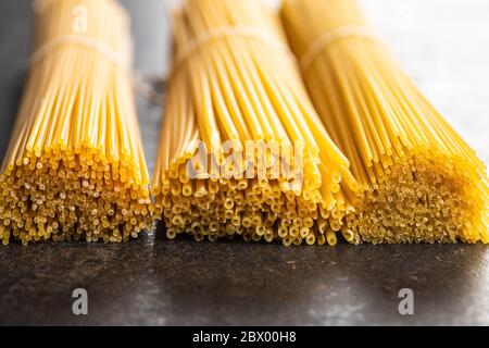Raw italian spaghetti pasta on black table. Stock Photo