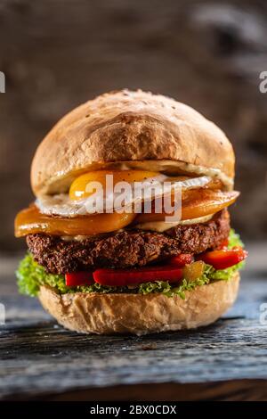 Vegetarian beans burger with double cheese, fried egg, peppers and salad Stock Photo