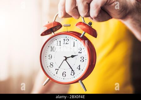 Cause time, rest time - A man keeps an alarm clock and shows time - concept - do not waste time in vain Stock Photo