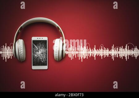 Mobile phone with empty broken black screen and earphones on red background with Audio track Stock Photo