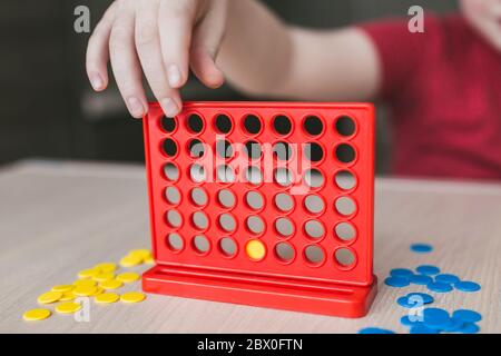 Intellectual board strategy game 'four in a row' - children play at the table Stock Photo