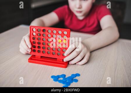 Intellectual board strategy game 'four in a row' - children play at the table Stock Photo