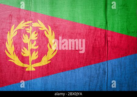 National flag of Eritrea  depicting in paint colors on old clothl. Flag  banner on  fabric texture background. Stock Photo