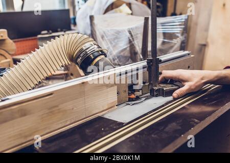 Carpenter workshop - master adjusts milling machine Stock Photo