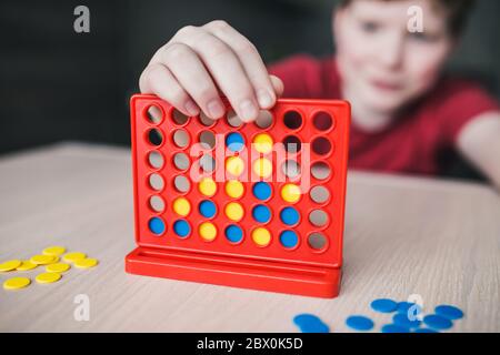 Intellectual board strategy game 'four in a row' - the child makes a winning move Stock Photo