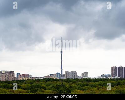 gray rainy clouds over residential district of Moscow city, TV tower and green park in spring Stock Photo