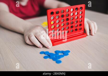 The boy wondered playing a board game four in line - home leisure Stock Photo