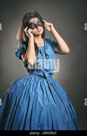 Beautiful woman wearing a black mask and blue elegant costume  . Venice carnival portrait Stock Photo