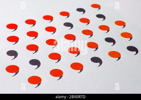 black comma in many red commas. Stock Photo
