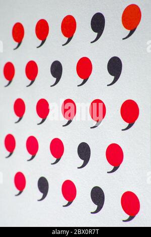 black comma in many red commas. Stock Photo