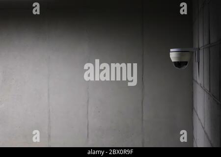 a security camera installed on a concrete wall. Stock Photo