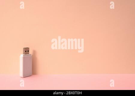 Pink color background and white USB memory storage. Stock Photo