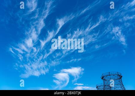 Blue sky with cirrus clouds, filigree ice clouds at high altitude, harbingers of warmer weather, chimneys, Stock Photo