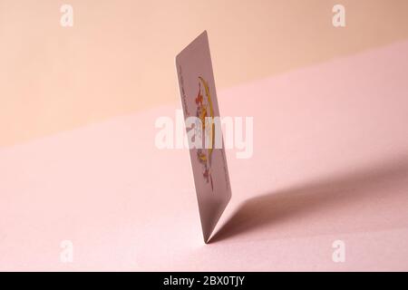 Joker playing card on pink background. Stock Photo