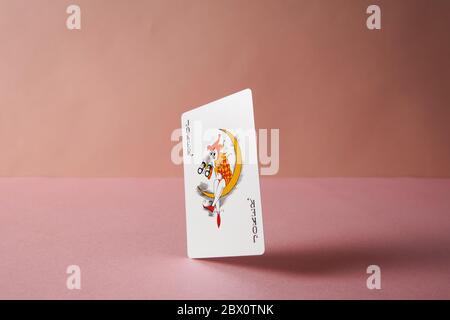 Joker playing card on pink background. Stock Photo