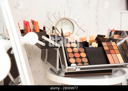 Case of professional makeup artist with decorative cosmetics on table Stock Photo
