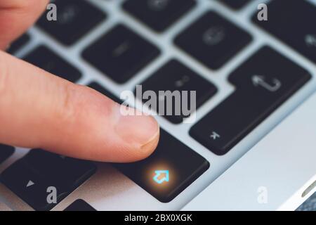 Closeup of Man's Finger Touching the Letter Shift Key button on Black Computer Keyboard Stock Photo