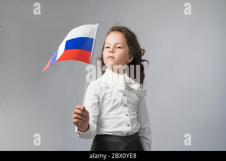 girl in a white shirt holding the flag of the Russian Federation Stock Photo