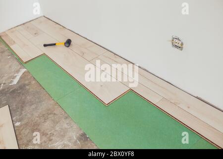 View of the process of installation and installation of new flooring in the interior decoration of the apartment Stock Photo