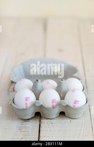 Six white shelled British Lion Standard eggs in a cardboard egg carton. Stock Photo