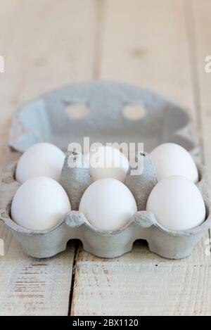 Six white shelled eggs in a cardboard egg carton. Stock Photo
