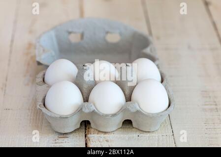 Six white shelled eggs in a cardboard egg carton. Stock Photo