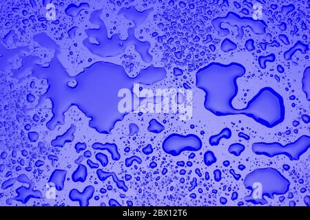 Transparent drops of water on a smooth and shiny colored surface. Water drops texture. Plain colored background with multiple drops of water Stock Photo