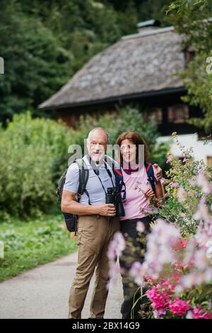 A senior pensioner couple with binoculars hiking, resting. Copy space. Stock Photo