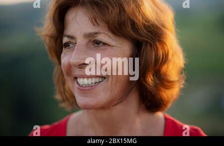 Portrait of senior tourist woman hiker standing in nature. Stock Photo
