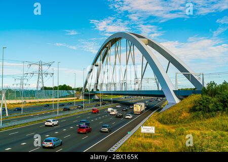 Amsterdam, July 9th, 2019 -commuters in cars and trucs passing the new railway bridge crossing the A1 motorway  from Amsterdam to the south of Holland Stock Photo