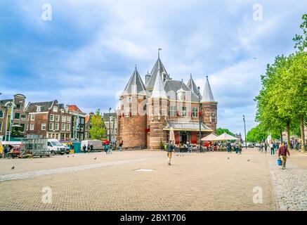 Amsterdam May 18 2018 - Locals and tourists wandering on the Nieuwmarkt square with the old Waagh (scale house) Stock Photo