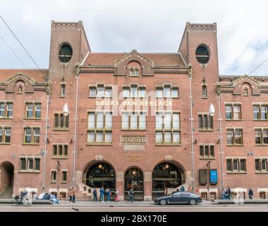 Amsterdam May 18 2018 - tourist and locals passing the old trading building Beurs van Berlage on the Damrak. Named after the architect who build it. Stock Photo