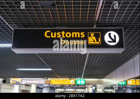 Customs sign at Schiphol international airport poiting passenergs to the customs area Stock Photo