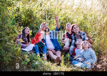 Group of school children with teacher on field trip in nature. Stock Photo