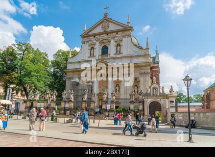 Krakau August 21th 2017: Tourists passing the old church (Kościół Rzymskokatolicki pw. Świętych Apostołów Piotra i Pawła) on Grodzka street in the cen Stock Photo