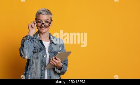 Modern Teacher. Portrait Of Stylish Mature Woman In Eyeglasses With Digital Tablet Stock Photo