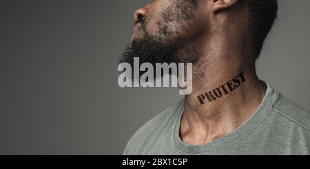 Close up portrait black man tired of racial discrimination has tattooed slogan protest on his neck. Concept of human rights, equality, justice, problem of violence and racism, discrimination. Flyer. Stock Photo