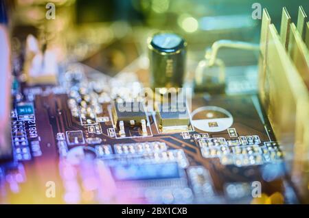 Computer motherboard background with blur neon multicolor glow, green and blue Stock Photo