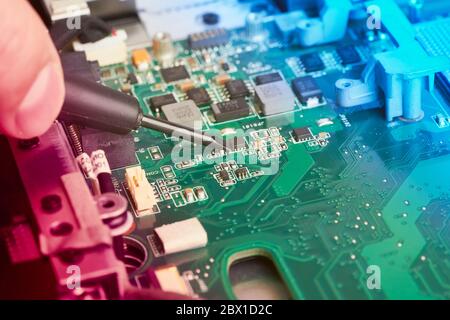 Man repairs computer. A service engineer in shirt repairs laptop, at white Desk Stock Photo