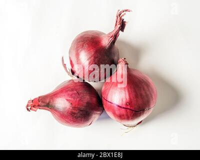 Three small red onions isolated on a white background Stock Photo