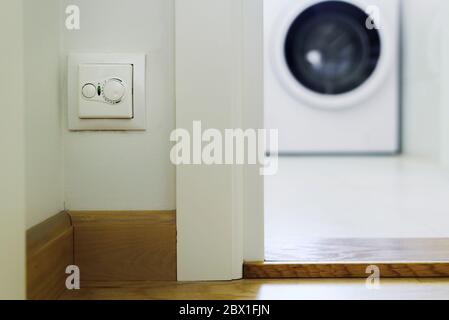 Thermostat for controlling heater in house near bathroom door with mechanical control Stock Photo