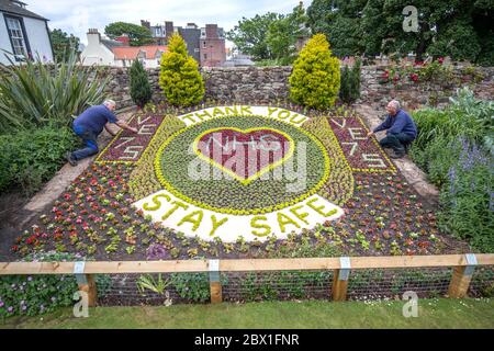 Bruce Collins (left) and Iain Tait, from East Lothian Council's Amenity Services put the finishing touches to the floral display they've help to create acknowledging the 75th anniversary of VE Day and thanking the NHS during the current Covid-19 pandemic in the Lodge Grounds at North Berwick. Stock Photo