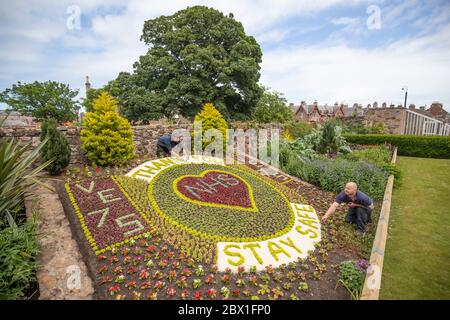 Rory Armatage (left) and Kyle Storrie, from East Lothian Council's Amenity Services put the finishing touches to the floral display they've help to create acknowledging the 75th anniversary of VE Day and thanking the NHS during the current Covid-19 pandemic in the Lodge Grounds at North Berwick. Stock Photo