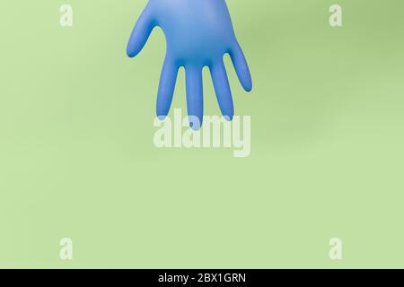 Latex inflated rubber glove inflated like balloons on a green background with copy space. Covid-19, stay at home Stock Photo