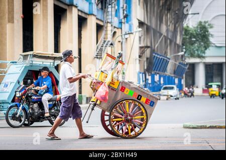 A street hawker passes under the Filipino Chinese Friendship Arch in the Binondo District, China Town, Manila, The Philippines. Stock Photo