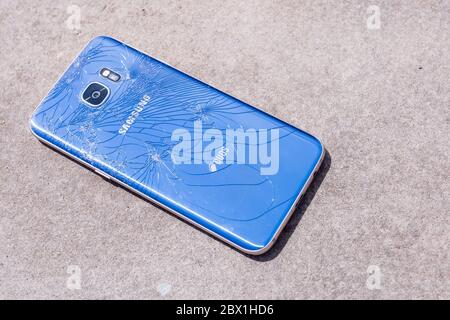 Seoul, South Korea - May 28, 2020: Broken blue mobile phone Samsung Galaxy S7 on the asphalt background. Stock Photo